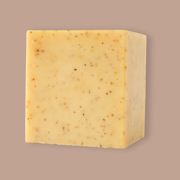 Unboxed bar of Lemon Pine Solid Dish Soap with warm yellow color and soapberry speckles