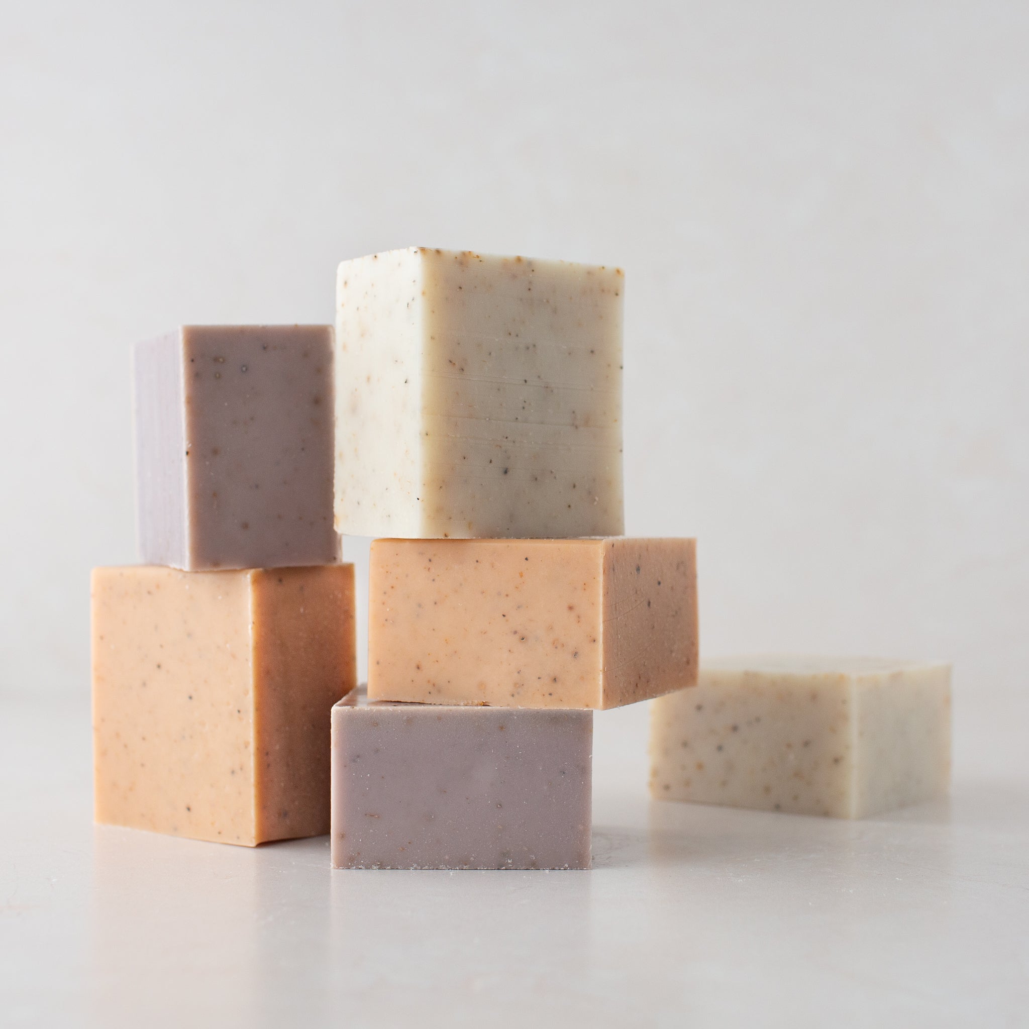 A grouping of Solid Dish Soap Sample Halves. A couple of each scent: Lavender, Citrus, and Unscented arranged organically on a white background.