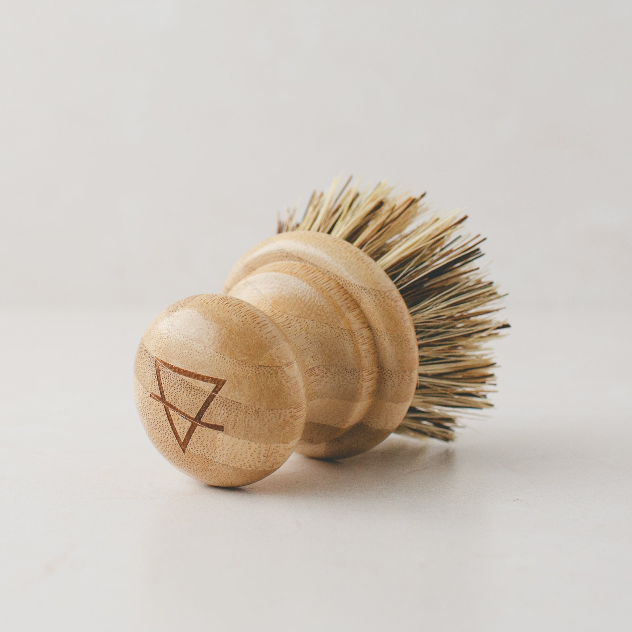 Pot scrub brush with natural fibers for effective scrubbing.