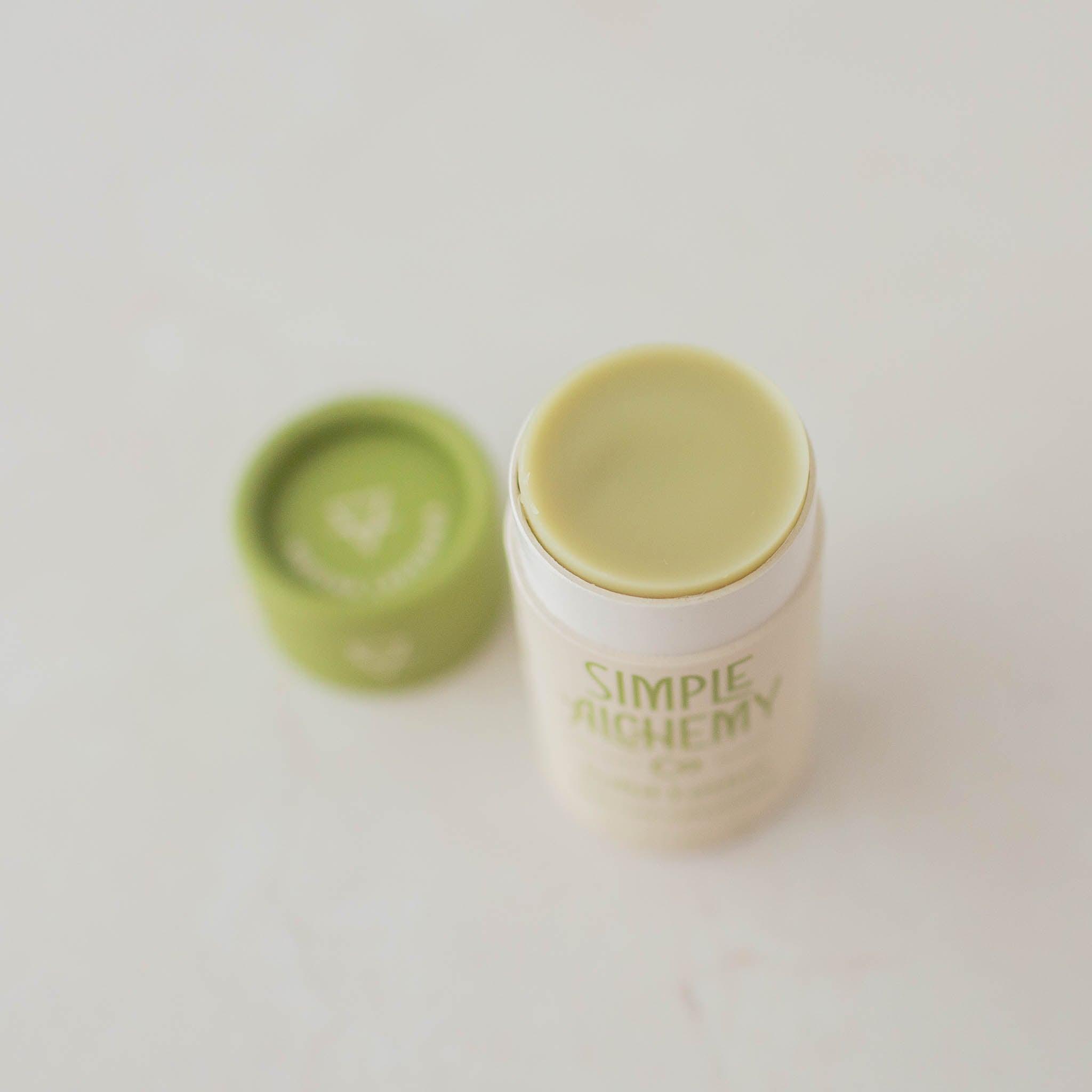 Green and cream compostable tube of Matcha Lavender Solid Lotion with cap off.