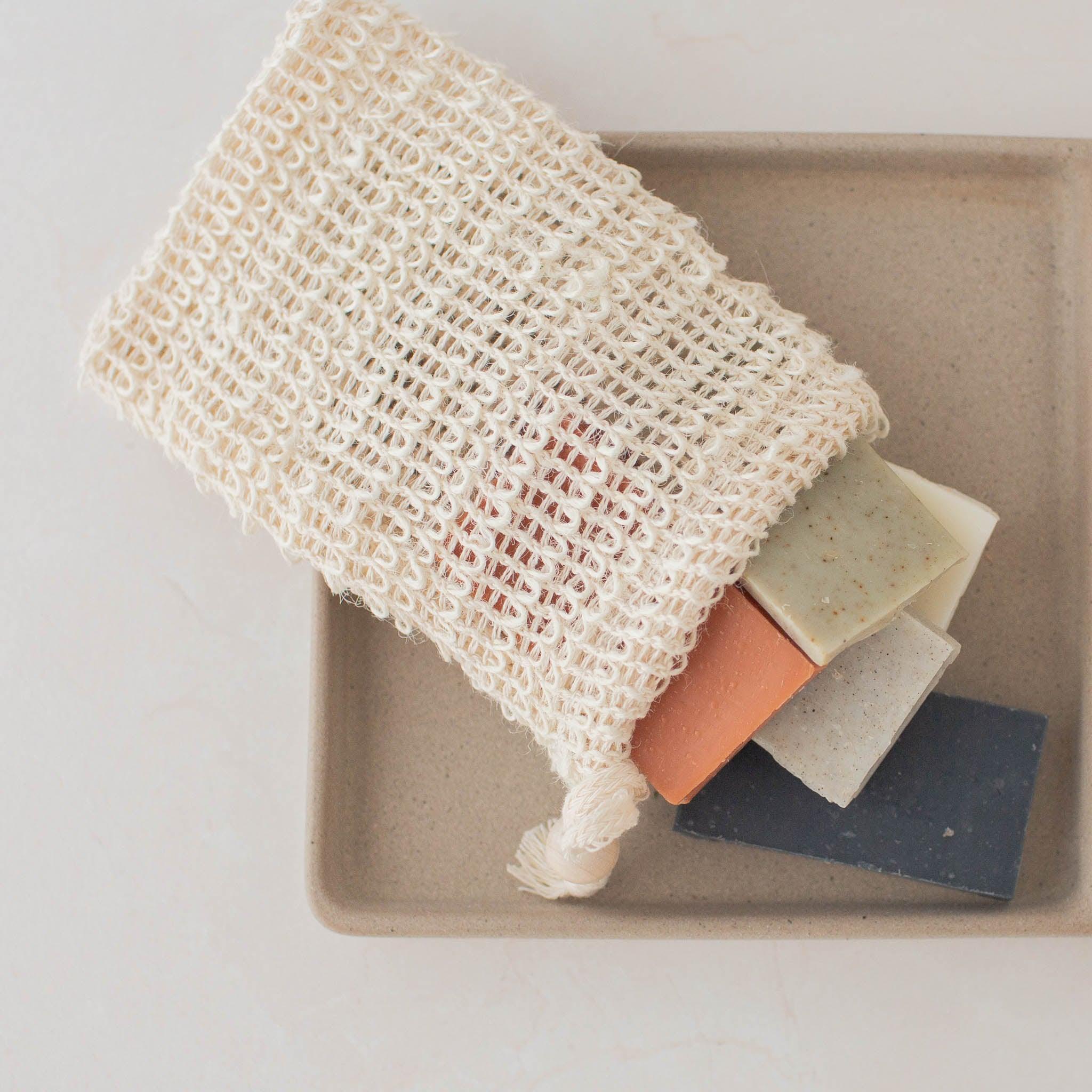 Compostable white woven sisal soap saver bag with soap inside.
