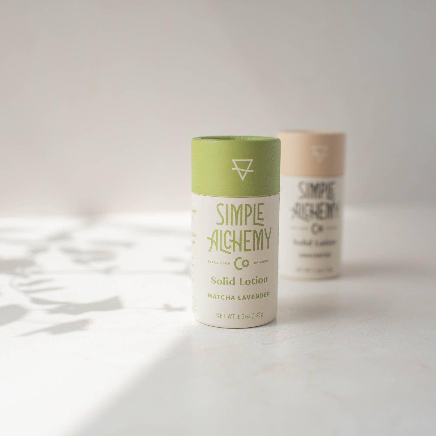 Matcha Lavender and Unscented Solid Lotions in compostable tubes on creamy white background
